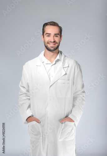 Young pharmacist on light background