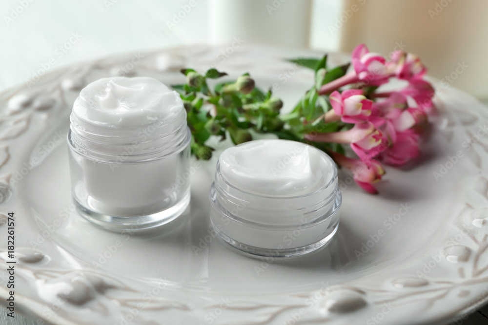 Jars of body cream on plate Jars of body cream on plate