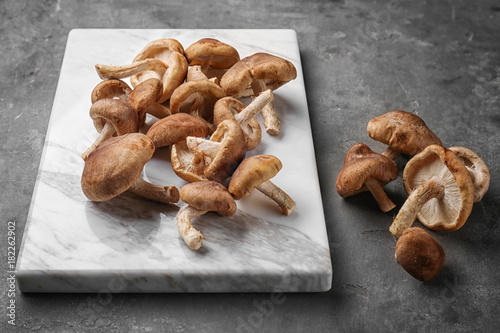 Board with raw shiitake mushrooms on table