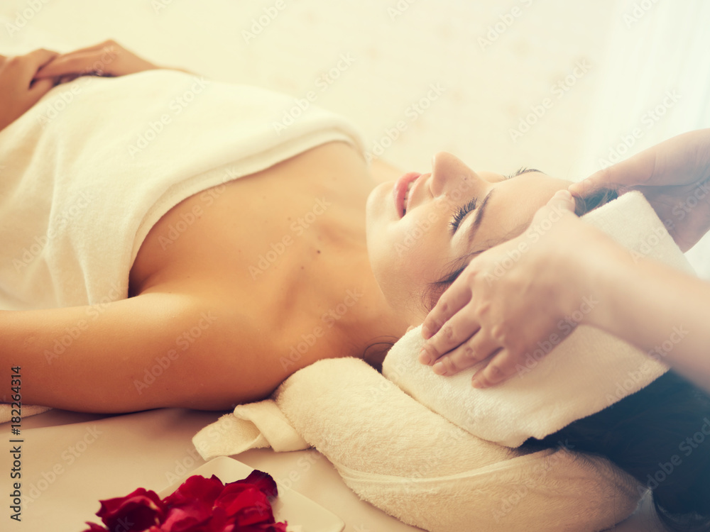 Masseur doing massage the head of an woman in the spa salon Masseur doing massage the head of an woman in the spa salon