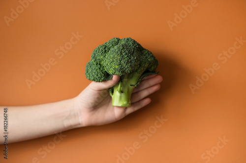 Raw broccoli in hand. Vegetarian food or diet concept.