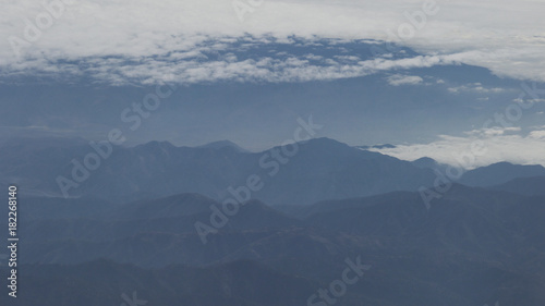 aerial shot from plane flying above the mountains in daytime