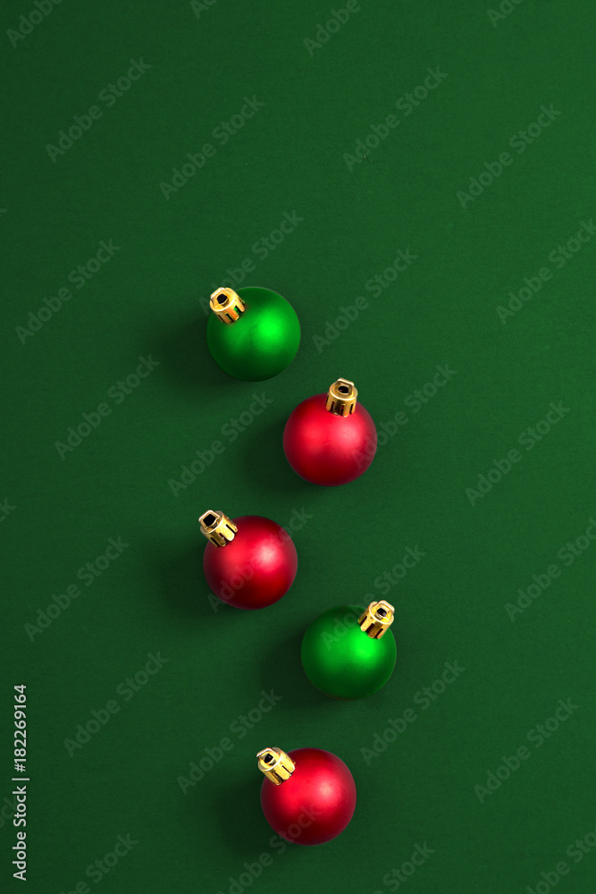 Christmas ornaments, green and red on a green background. Top view. Copy space