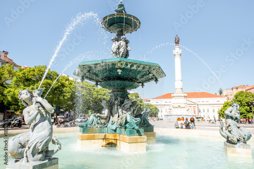 Beautiful view on the fountain on the Rossio square with column during the sunny day in Lisbon city, Portugal