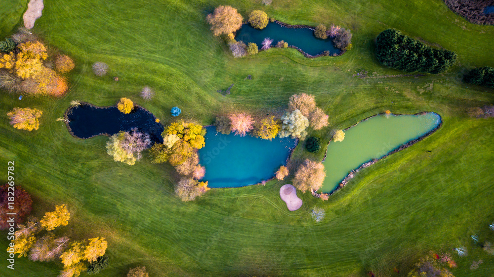 Obraz Drone view of a golf course with colorful trees and a beautiful surrounding nature