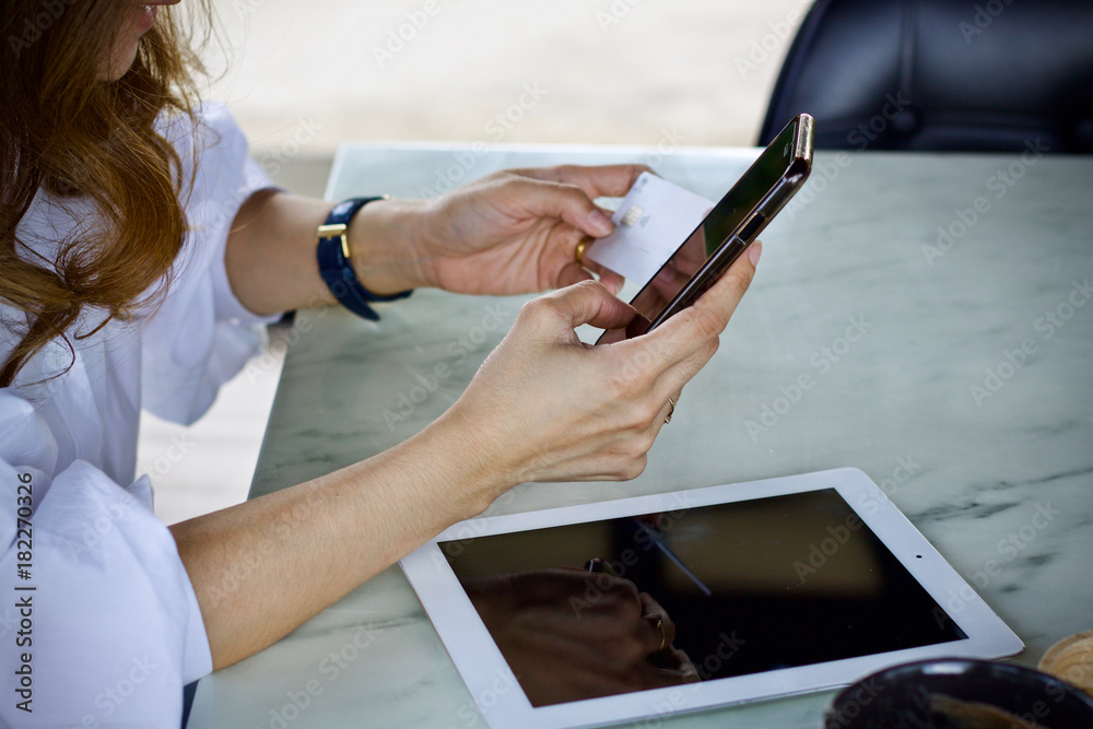 Woman using laptop smartphone paying online Woman using laptop smartphone paying online