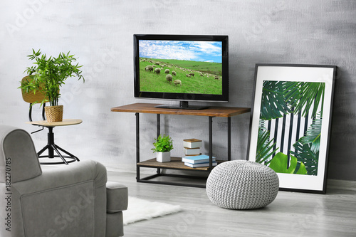 Modern TV set on stand in l...