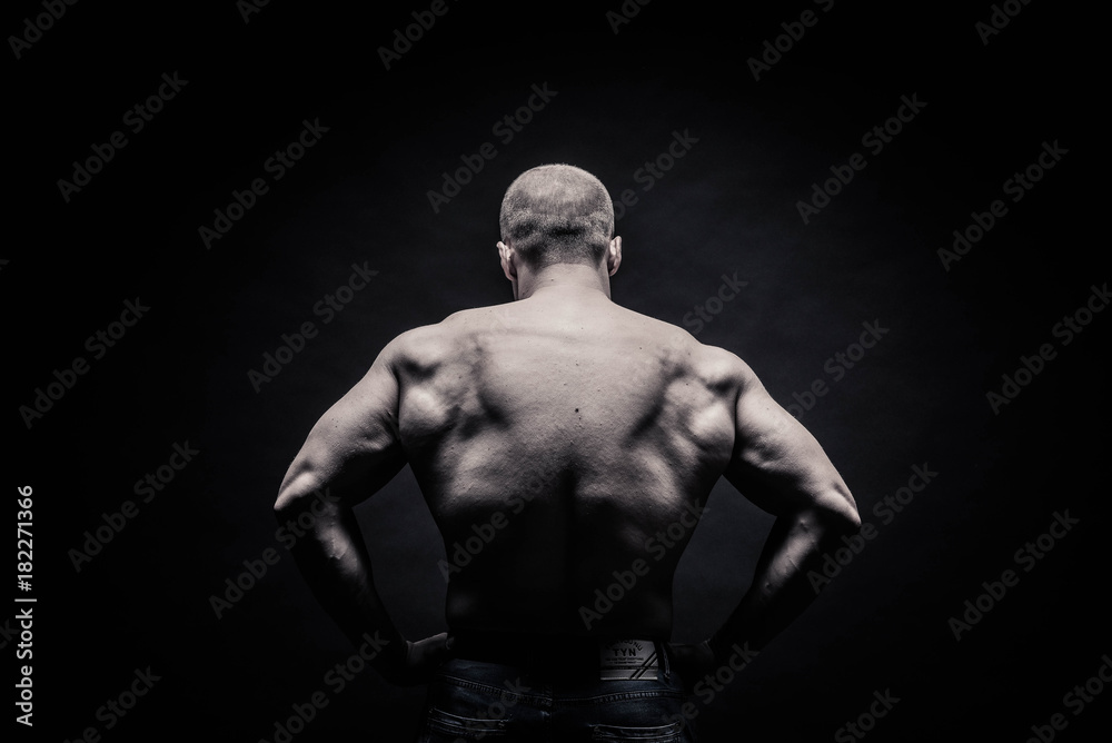 portrait of a male bodybuilder on a black background isolated. monochrome. The concept of a photo of competing sports, health, fitness