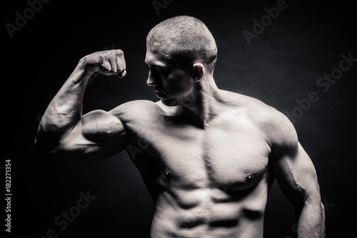 portrait of a male bodybuilder on a black background isolated. monochrome. The concept of a photo of competing sports, health, fitness