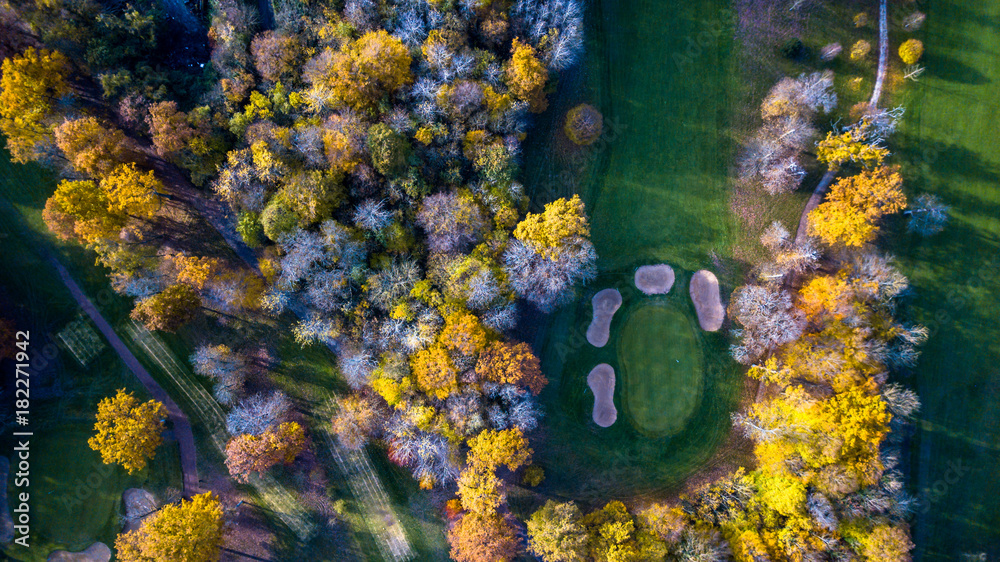 Obraz Drone view of a golf course with colorful trees and a beautiful surrounding nature