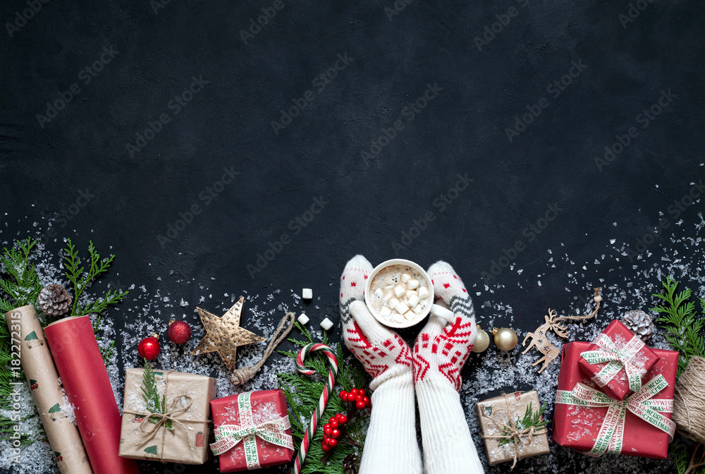 Fototapeta premium Christmas design Christmas . Christmas black background c fir tree, gift boxes, hot drinks, cocoa, coffee or hot chocolate with marmalade, Christmas decorations, Santa hat, star.
