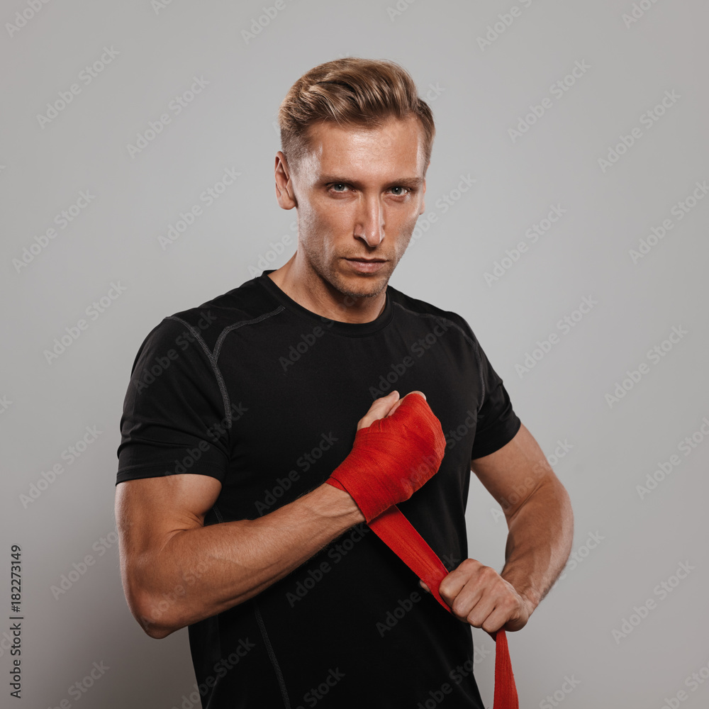 Confident man bandaging fists