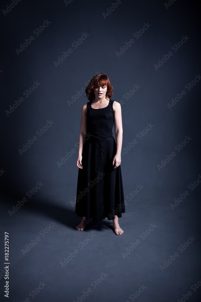 Dancer in a black dress is dancing in the dark studio Dancer in a black dress is dancing in the dark studio