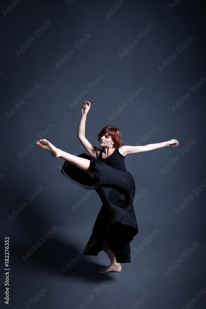 Dancer in a black dress is dancing in the dark studio Dancer in a black dress is dancing in the dark studio