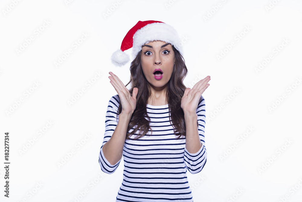 How is this possible? Attractive young smiling woman in santa hat posing on white background isolated. How is this possible? Attractive young smiling woman in santa hat posing on white background isolated.