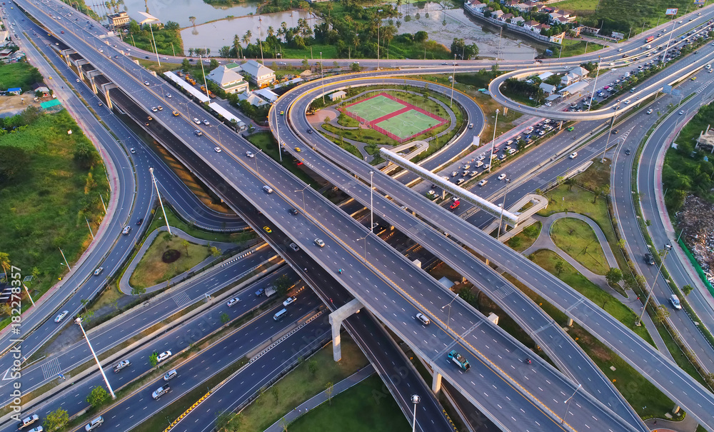 Aerial view Road roundabout, Expressway with car lots in the city in Thailand.beautiful Street , downtown,cityscape,Top view. Background,Aerial view city scape Aerial view Road roundabout, Expressway with car lots in the city in Thailand.beautiful Street , downtown,cityscape,Top view. Background,Aerial view city scape