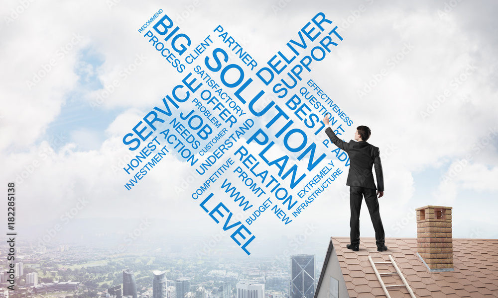 Young businessman standing on house roof and writing leadership skill concept. Mixed media Young businessman standing on house roof and writing leadership skill concept. Mixed media