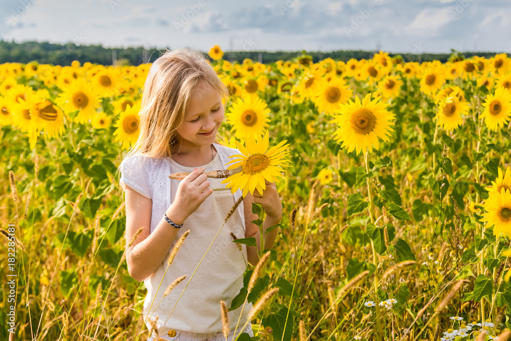 Fototapeta premium girl paints sunflowers in a field