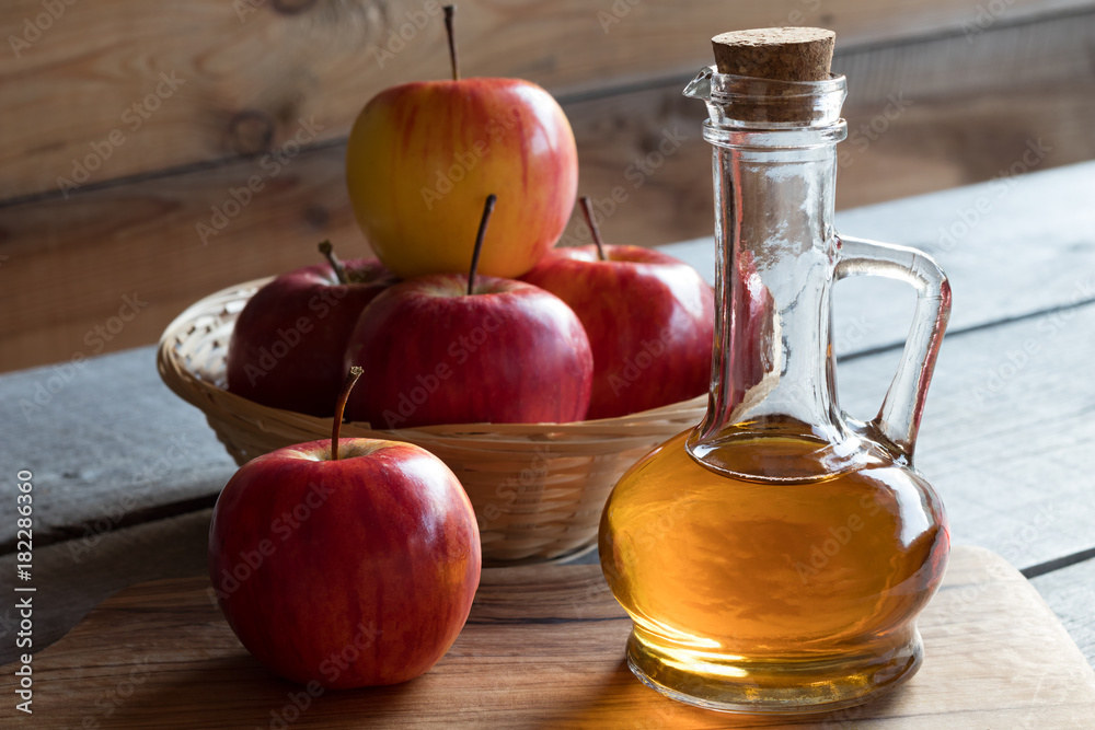A bottle of apple cider vinegar with apples A bottle of apple cider vinegar with apples