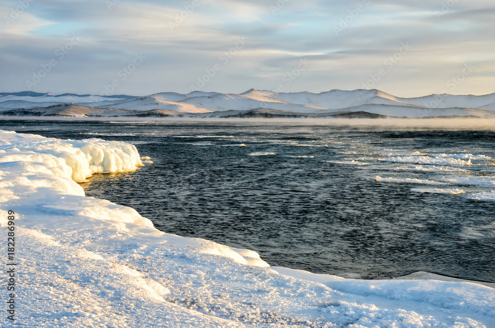 Ice floes floating on the fog water in the lake Baikal. Sunset Ice floes floating on the fog water in the lake Baikal. Sunset