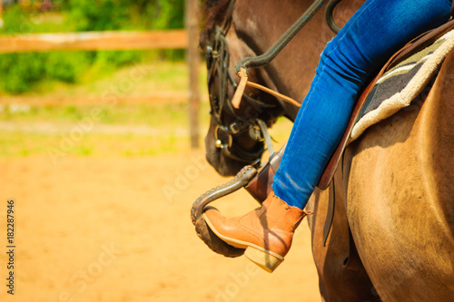 Woman foot in stirrup on horse saddle © Voyagerix