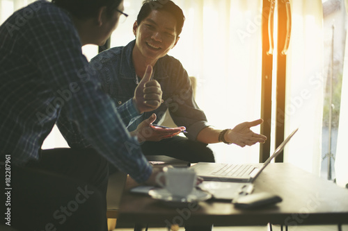 Happy business people looking at report and having a discussion in office.