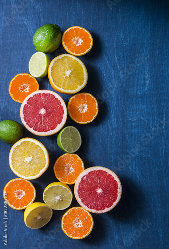 Assortment of citrus fruits on a blue background, top view. Oranges, grapefruit, tangerine, lime, lemon - organic fruits, vegetarian healthy food concept © okkijan2010