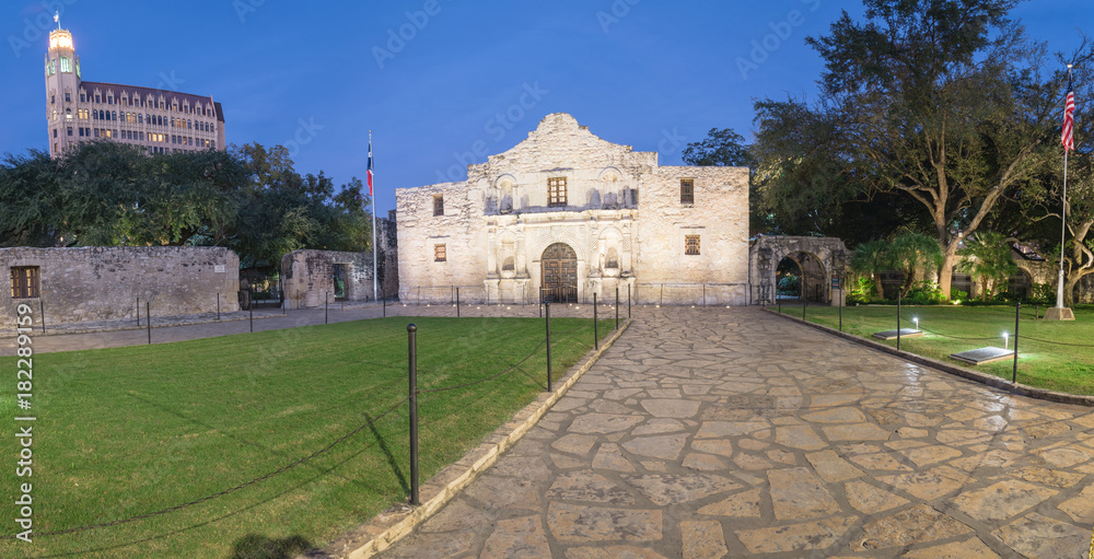 Panorama view the Alamo Mission in San Antonio at blue hour. It is commonly called The Alamo and was known as Misión San Antonio de Valero. A top-rated, rich colonial heritage tourist attraction - obrazy, fototapety, plakaty 