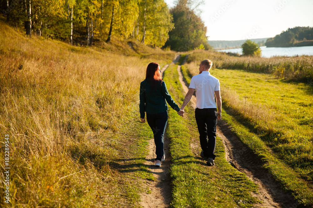 Young loving married couple on the river bank, man and beautiful girl on nature in summer Young loving married couple on the river bank, man and beautiful girl on nature in summer
