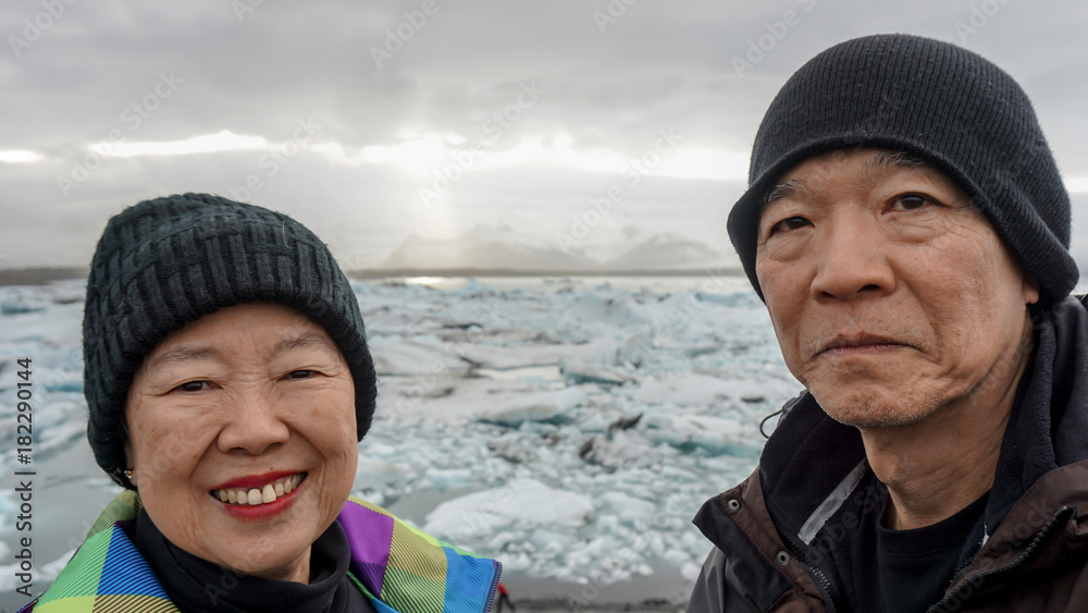 Asian senior couple fun trip in Iceland, majestic glacier lagoon landscape Asian senior couple fun trip in Iceland, majestic glacier lagoon landscape