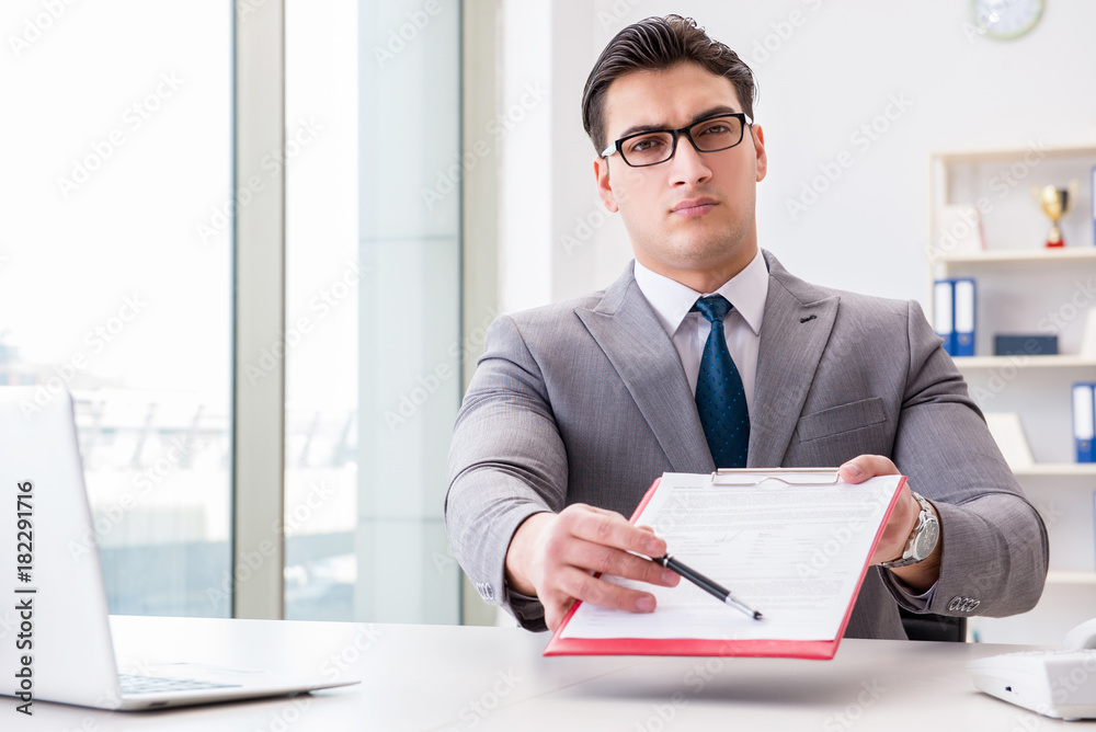 Businessman signing business documents in office Businessman signing business documents in office