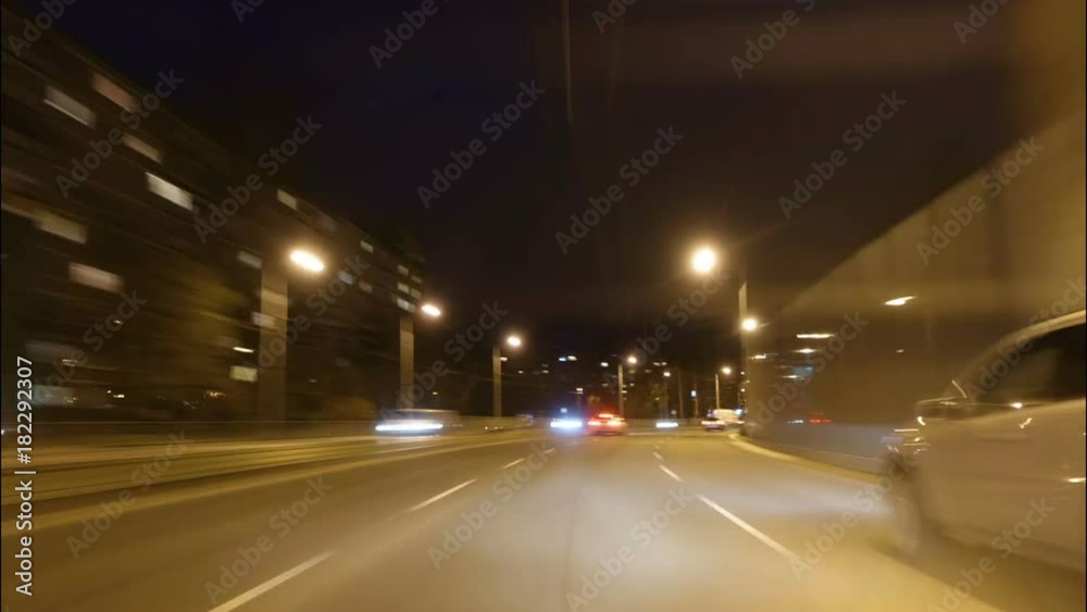 Time lapse of driving a car in the city at night time. POV. Hyper laps in the evening downtown.
