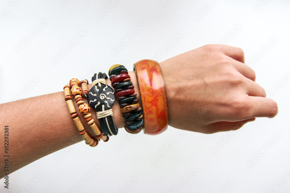 Fototapeta premium Ethnic bracelets on a thin female hand on white background
