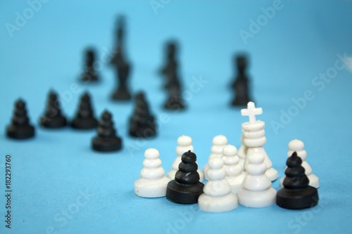 Black annd white chess pieces with black in distance  illegal migration metaphor conceptual theme.