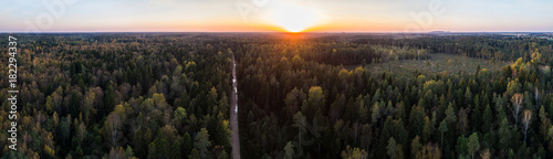 Aerial view of road among autumn forest in Estonia. Panorama. Sunset. © nikwaller