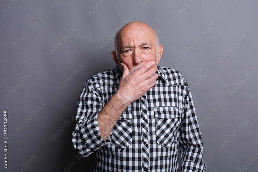 Surprised senior man covering mouth with hand Surprised senior man covering mouth with hand