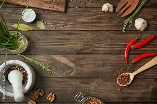 Kitchen utensils, vegetables and spice on wooden background