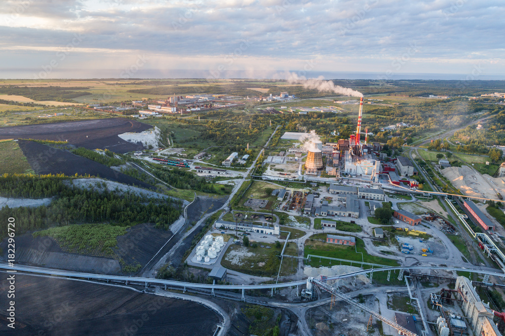 Fototapeta Aerial view Oil refinery with a background of mountains and sky at sunset. Aerial photography. Kohtla-Järve city, Estonia, Ida-Virumaa.