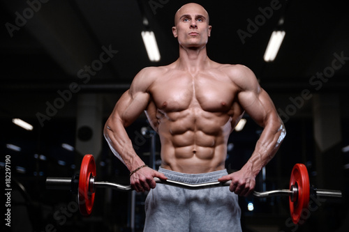 Brutal strong bodybuilder athletic men pumping up muscles with dumbbells.