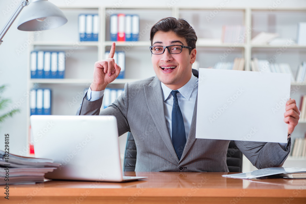 Businessman in office holding a blank message board Businessman in office holding a blank message board