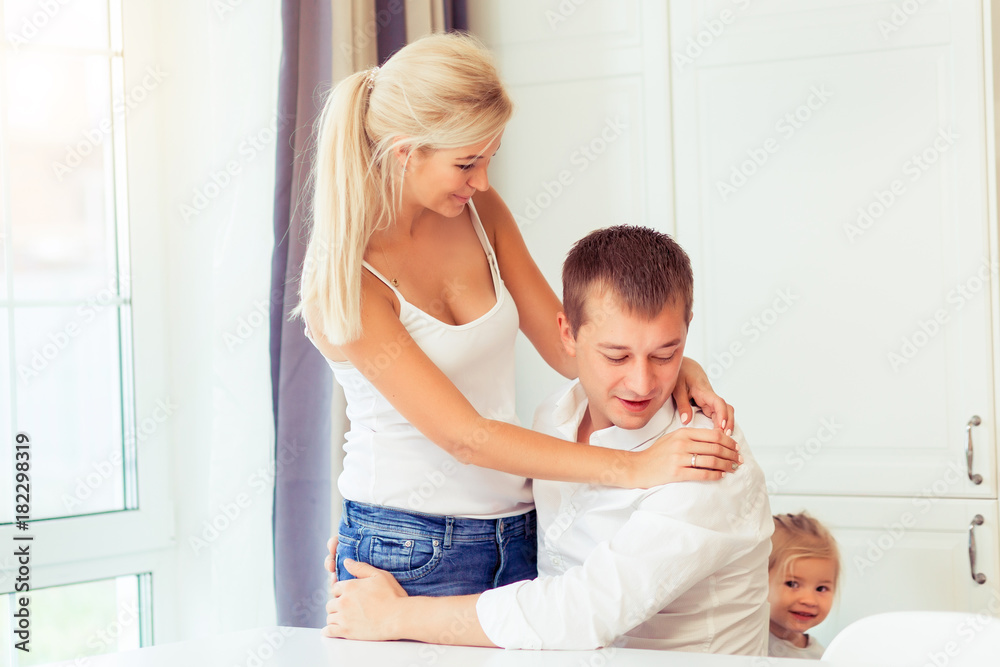 Smiling young parents and their little child are very happy at kitchen home Smiling young parents and their little child are very happy at kitchen home