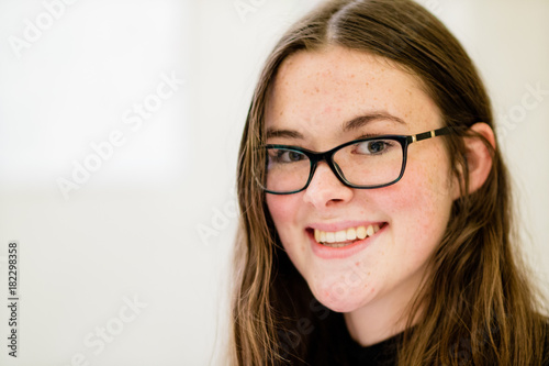 A young lady wearing glasses, smiling at the camera