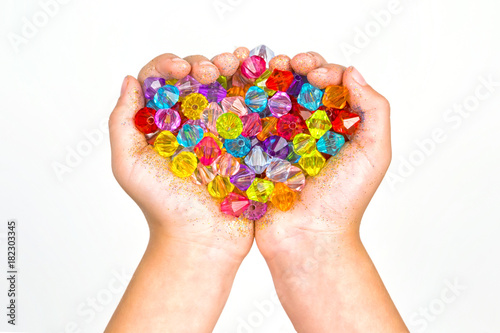 children's hands, hands holding beads on a white background