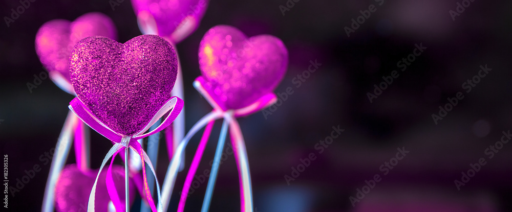 Fototapeta premium Valentines day. Pink hearts on dark blurred background close-up with copy space for congratulation, border design panoramic banner 