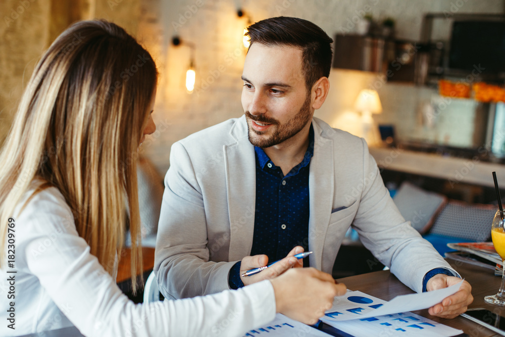 Businessman and business woman have a meeting in a cafe Businessman and business woman have a meeting in a cafe