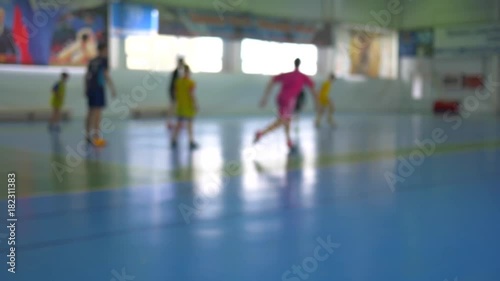 Football futsal training for children. Indoor soccer young player with a soccer ball in a sports hall. photo