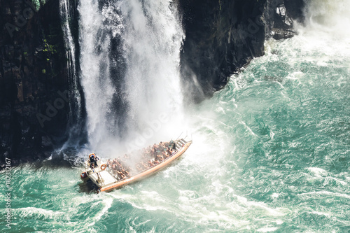 Boat under a waterfall photo