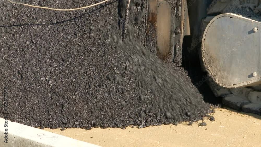 Asphalt paver machine during road construction close up Asphalt paver machine during road construction close up