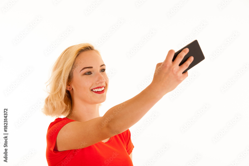 Attractive young blond woman making selfie with her smart phone isolated over white background
