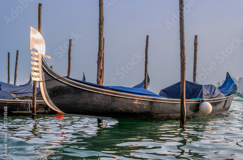 Gondolas in Venice. The gondolas are moored at the mooring posts. Venice, Italy.